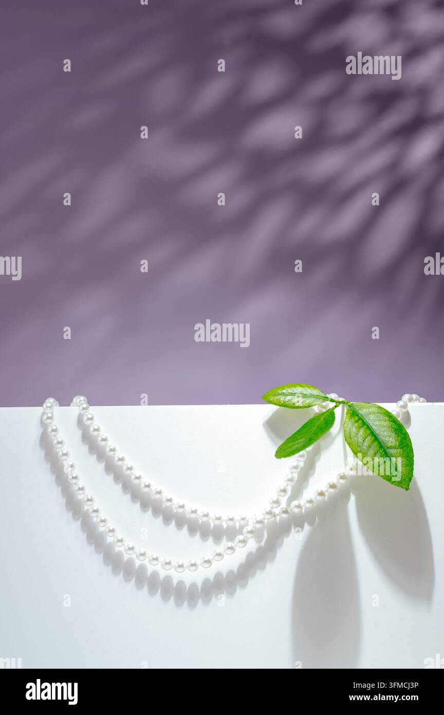 Elegante collana di perle con foglie e ombre screziate Foto Stock