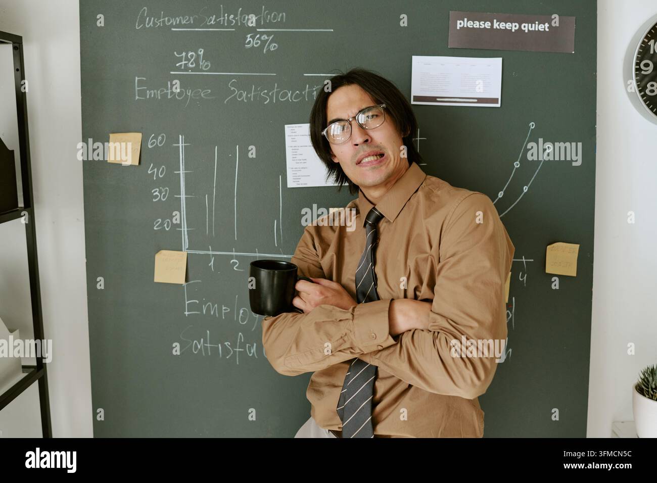 Ritratto di uomo adulto frustrato che tiene una tazza di caffè in ufficio Foto Stock