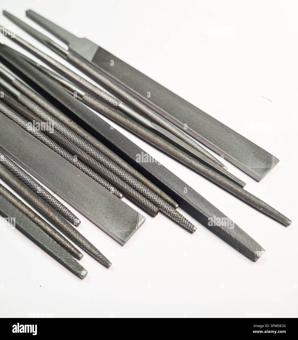 Vari lime metalliche di forme diversa disposte su uno sfondo bianco pulito, adatte per concetti industriali, da officina, artigianali e tecnici. Foto Stock