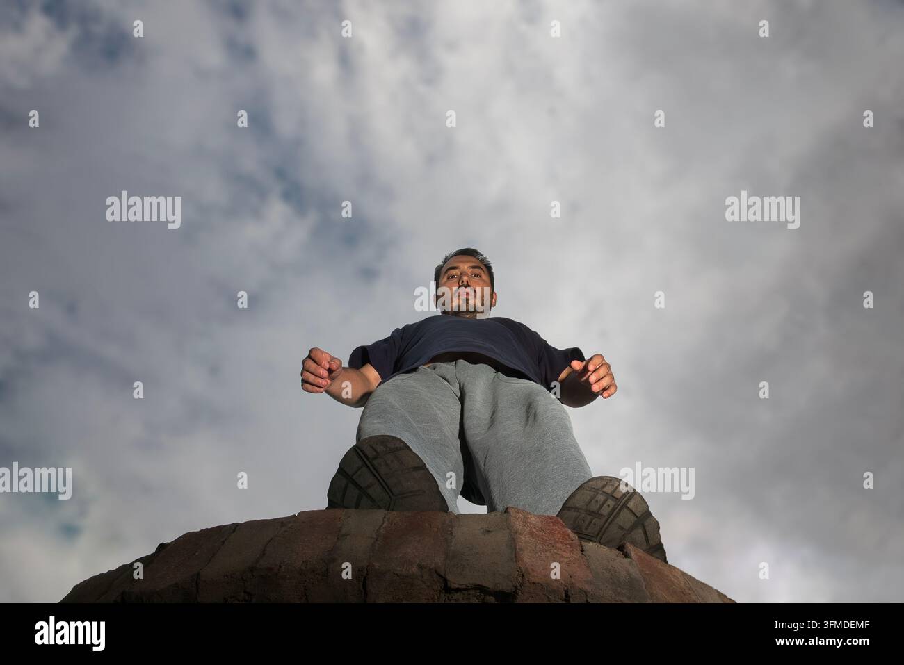 un uomo in piedi sul bordo di una scogliera con l'intenzione di saltare Foto Stock