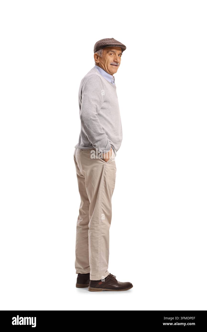 Uomo anziano con berretto piatto e maglione in piedi di profilo e che guarda indietro Foto Stock
