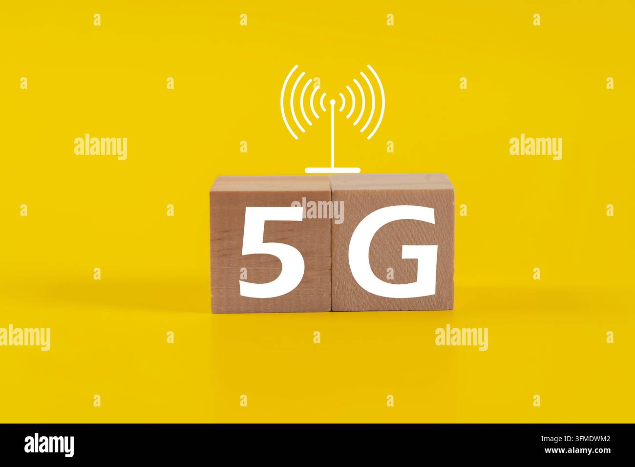 Blocchi di legno che compongono la scritta 5G su uno sfondo giallo brillante. Icona bianca del segnale wireless sopra i blocchi. Concetto tecnologico moderno per le reti mobili. Buono per Marketi Foto Stock