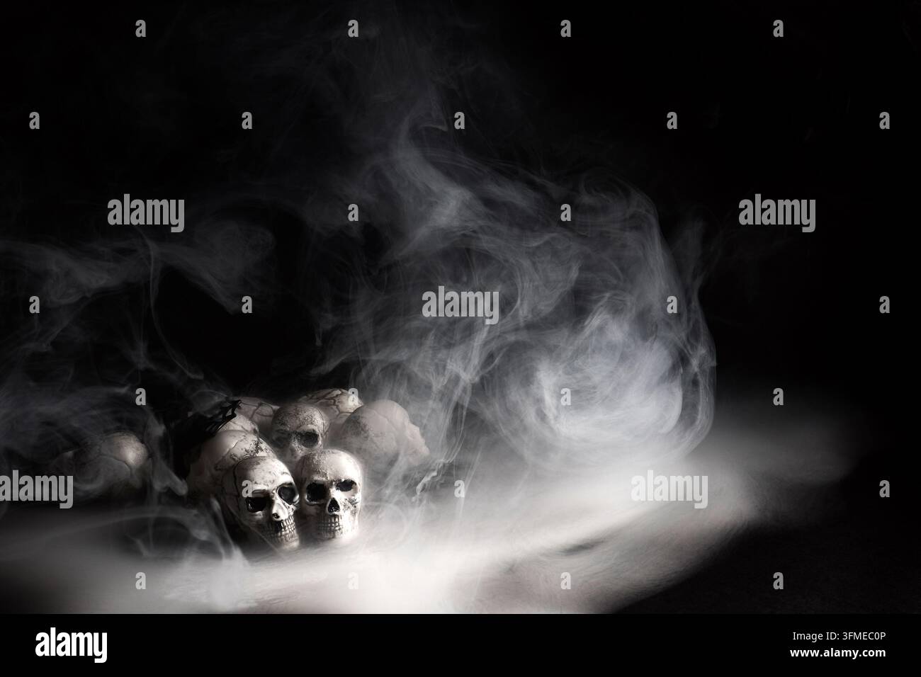 Teschi umani che emergono da una misteriosa nebbia fumosa Foto Stock