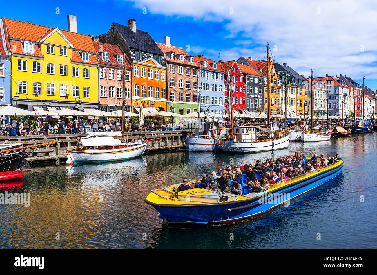 Copenaghena, Danimarca, 11 maggio 2025: Vecchio porto di Nyhavn con navi ed edifici colorati, centro storico, meta turistica europea Foto Stock