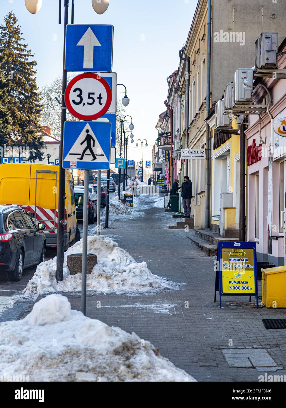 Viale cittadino innevato con segnali stradali ed edifici Foto Stock