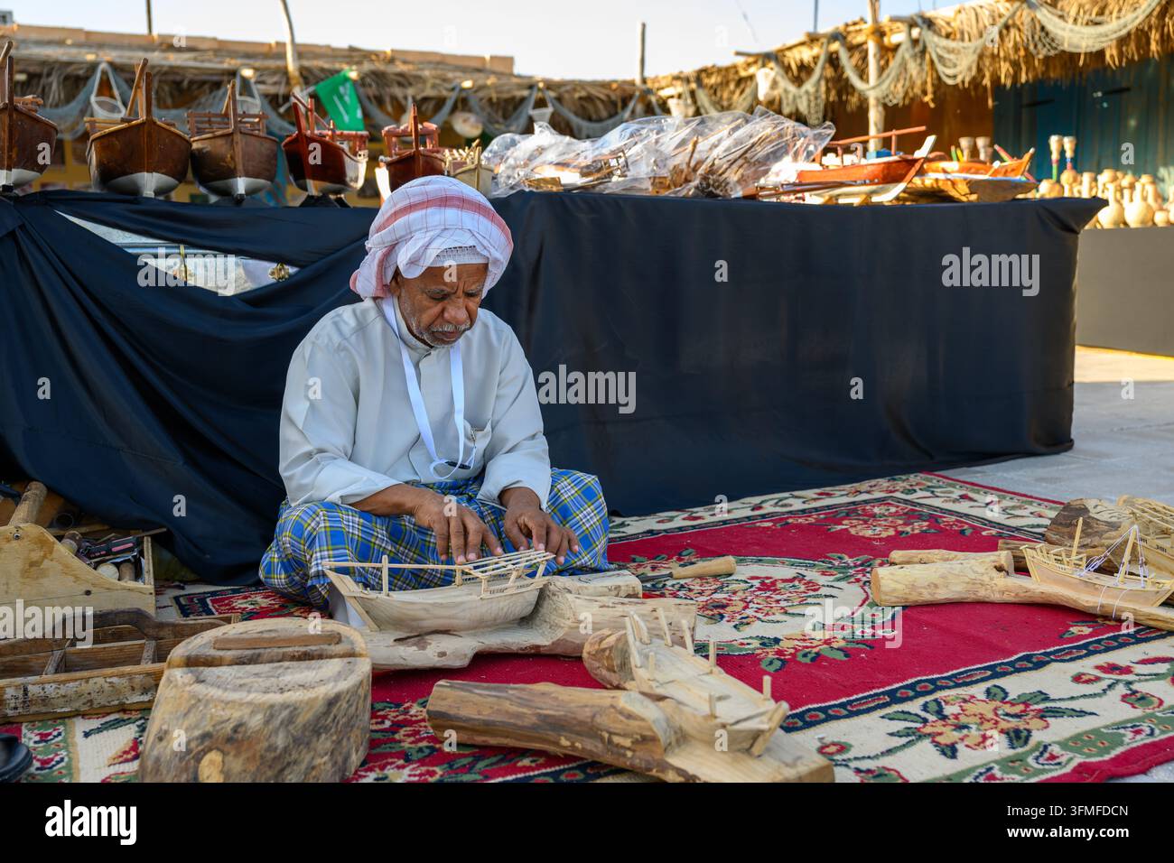 Doha, Qatar – 29 novembre 2023: Un primo piano di un documentario del Festival tradizionale dei dhow di Katara che mostra un artigiano che pratica con precisione il t Foto Stock