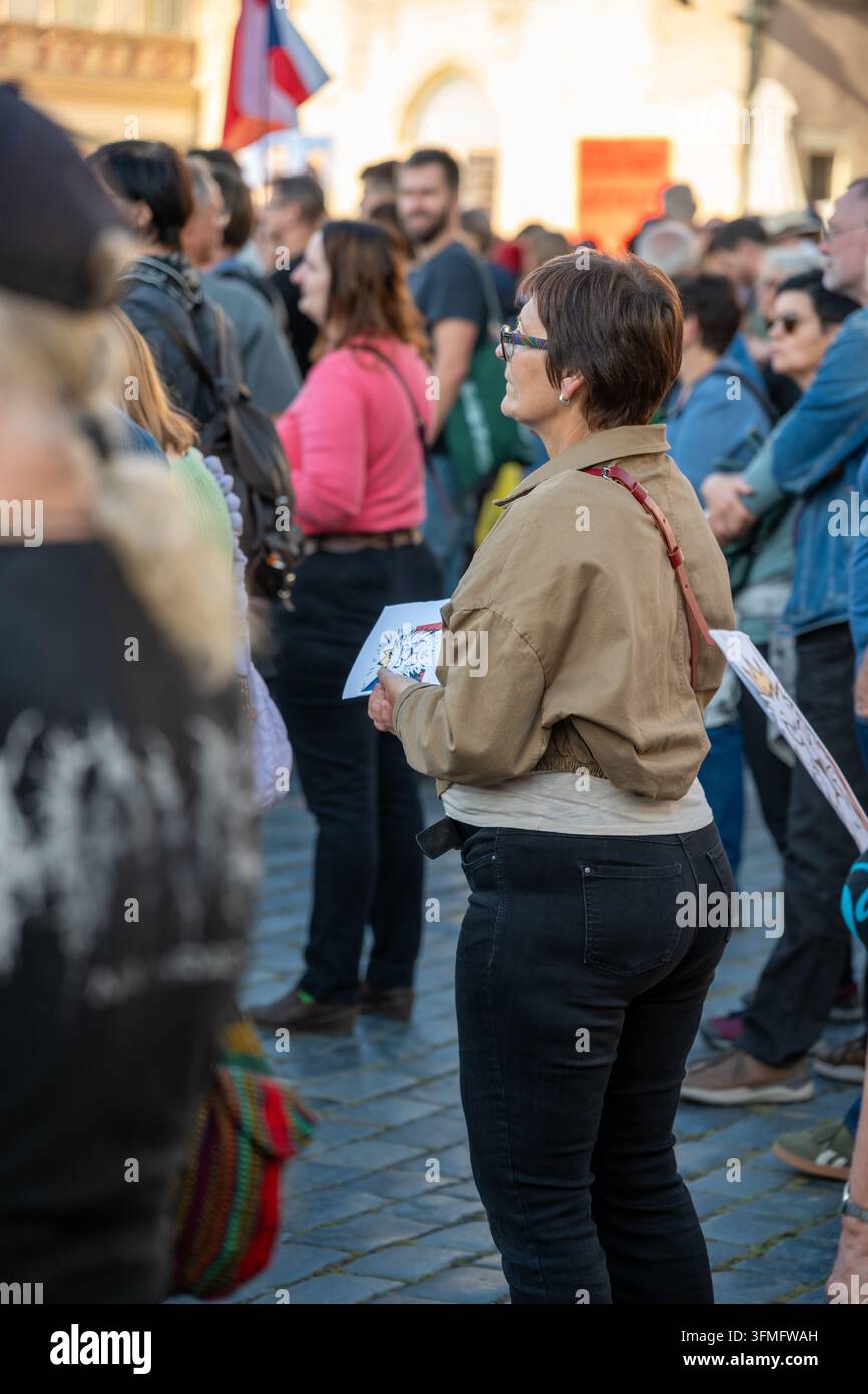 Donna che tiene materiale stampato ascolta durante la manifestazione "Million Moments for Democracy" che incoraggia la partecipazione elettorale. Praga, Repubblica ceca Foto Stock