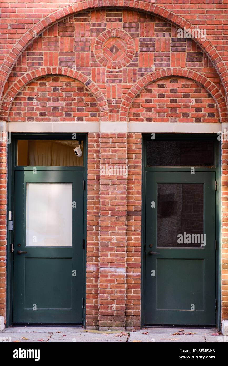 Doppie porte verdi e muratura elegante con archi decorati Foto Stock