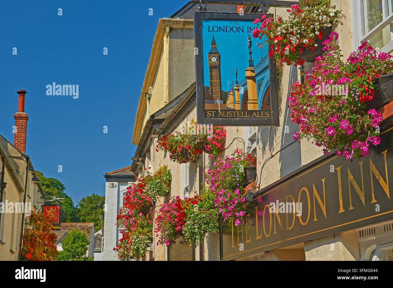 The London Inn a Padstow, Cornovaglia, con cesti appesi colorati e un cielo blu limpido Foto Stock