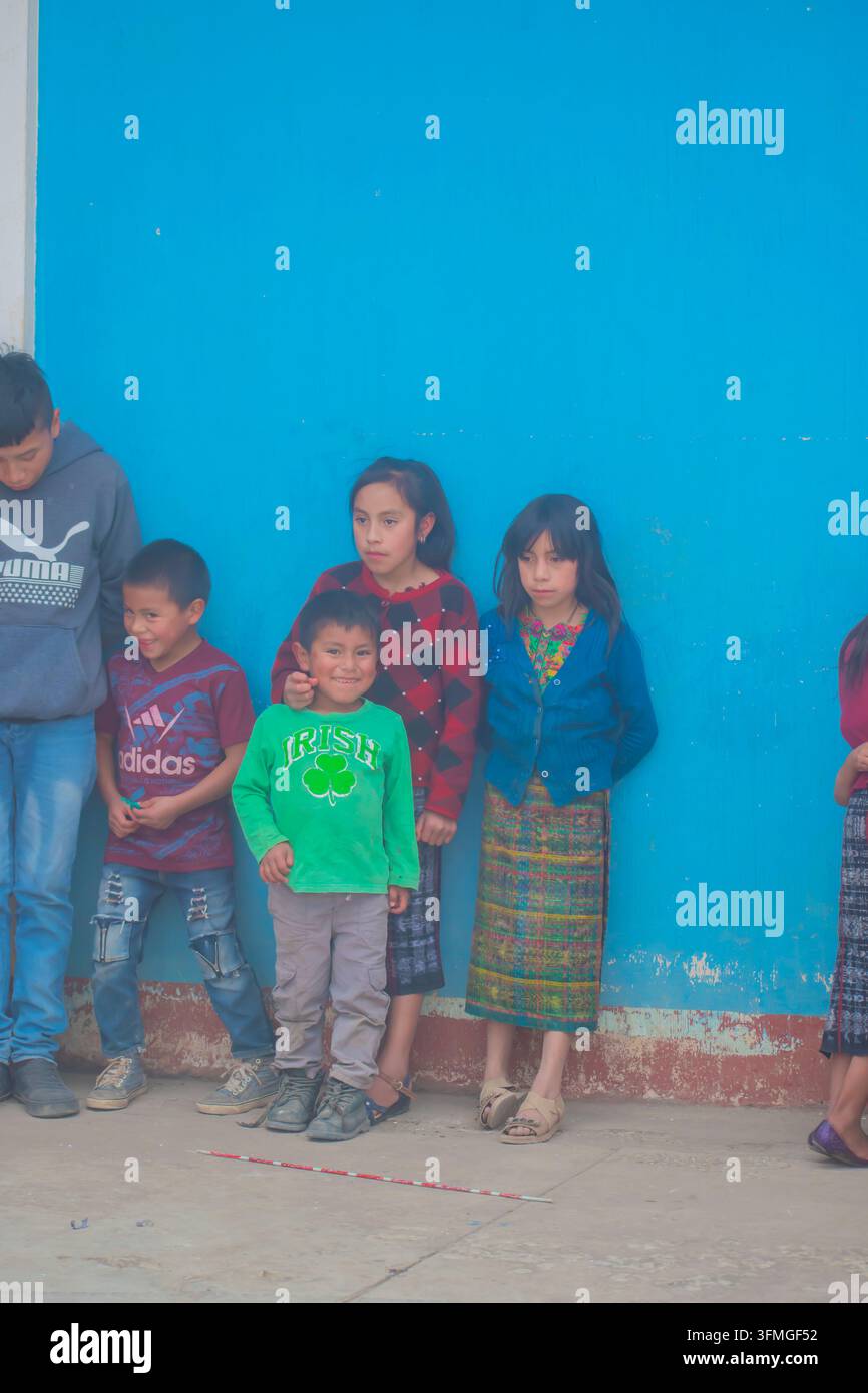 bambini che giocano e ricevono regali da persone, donne indigene di Cajola accompagnate dai loro figli Foto Stock