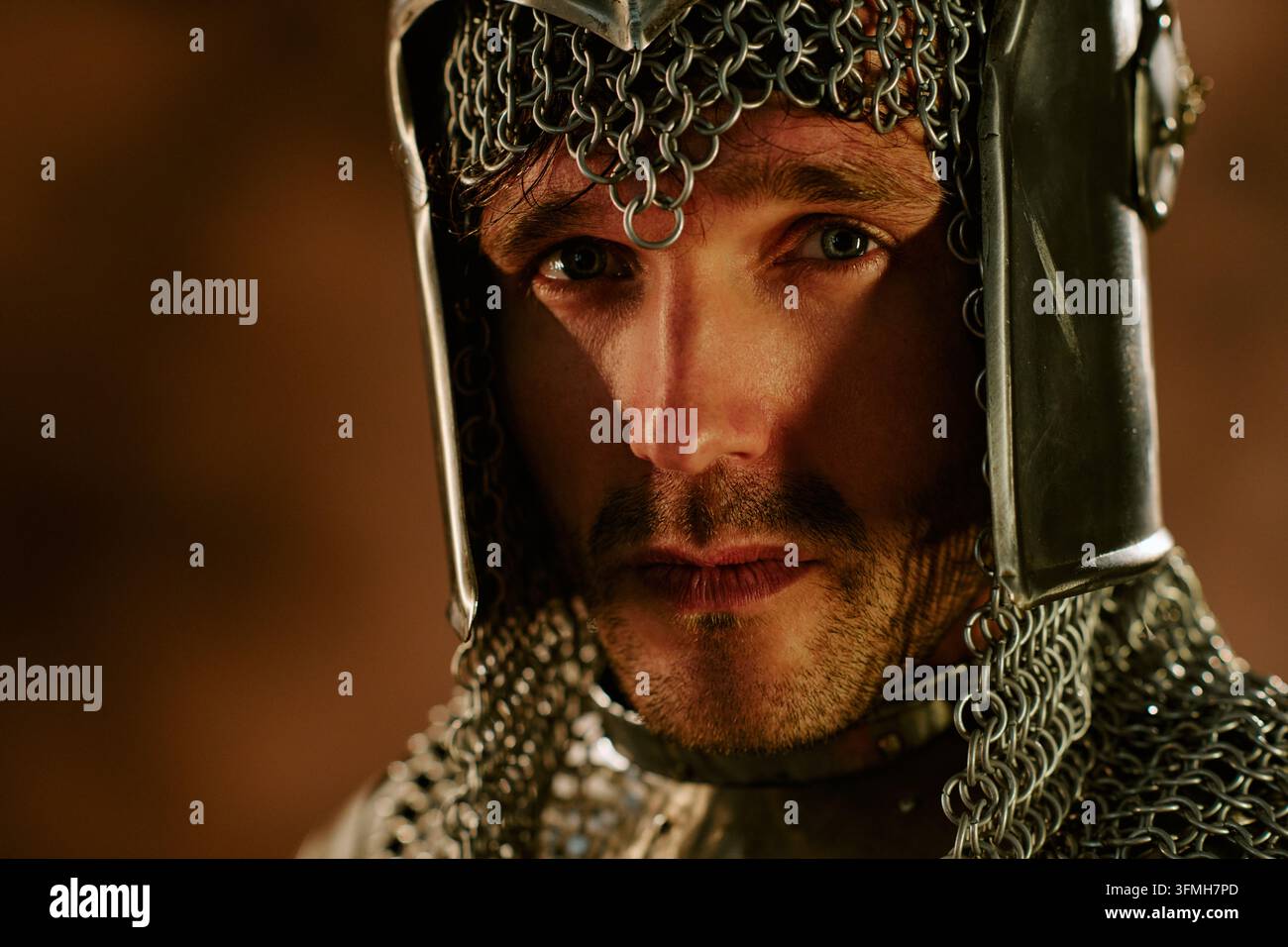 Ritratto di uomo con armatura da cavaliere medievale che guarda l'obiettivo Foto Stock