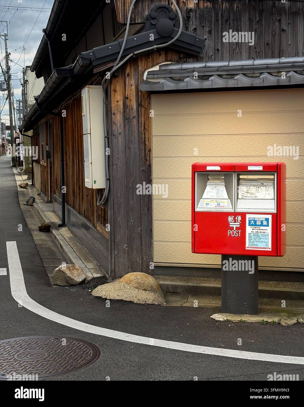 Cassetta postale rossa giapponese su una strada tradizionale in legno a Nara - Immagine stock catturata con smartphone