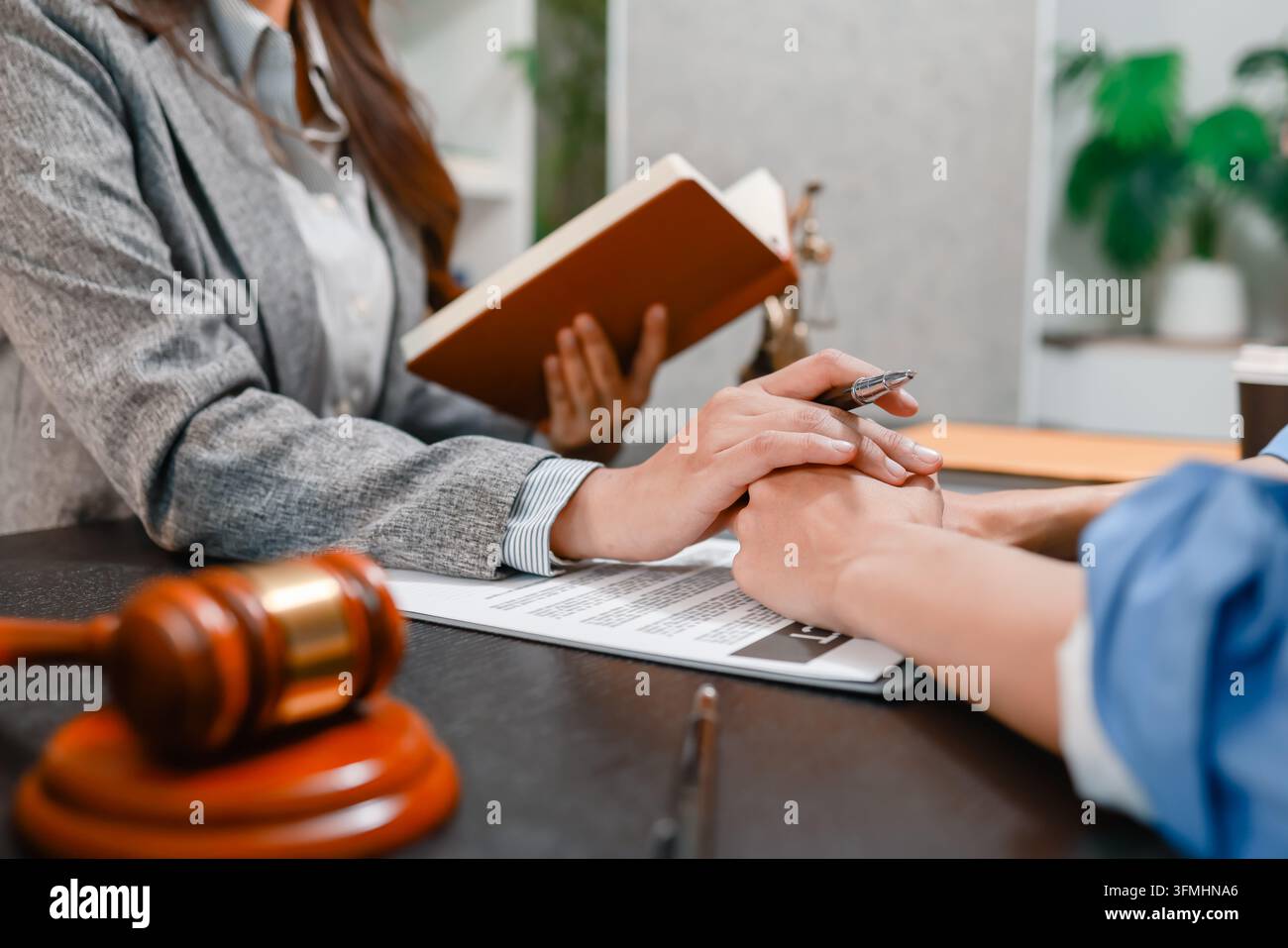 Consulenza legale professionale tra un avvocato e un cliente che discutono di contratti, diritti legali, strategia del caso e revisione dei documenti in un ufficio legale moderno Foto Stock