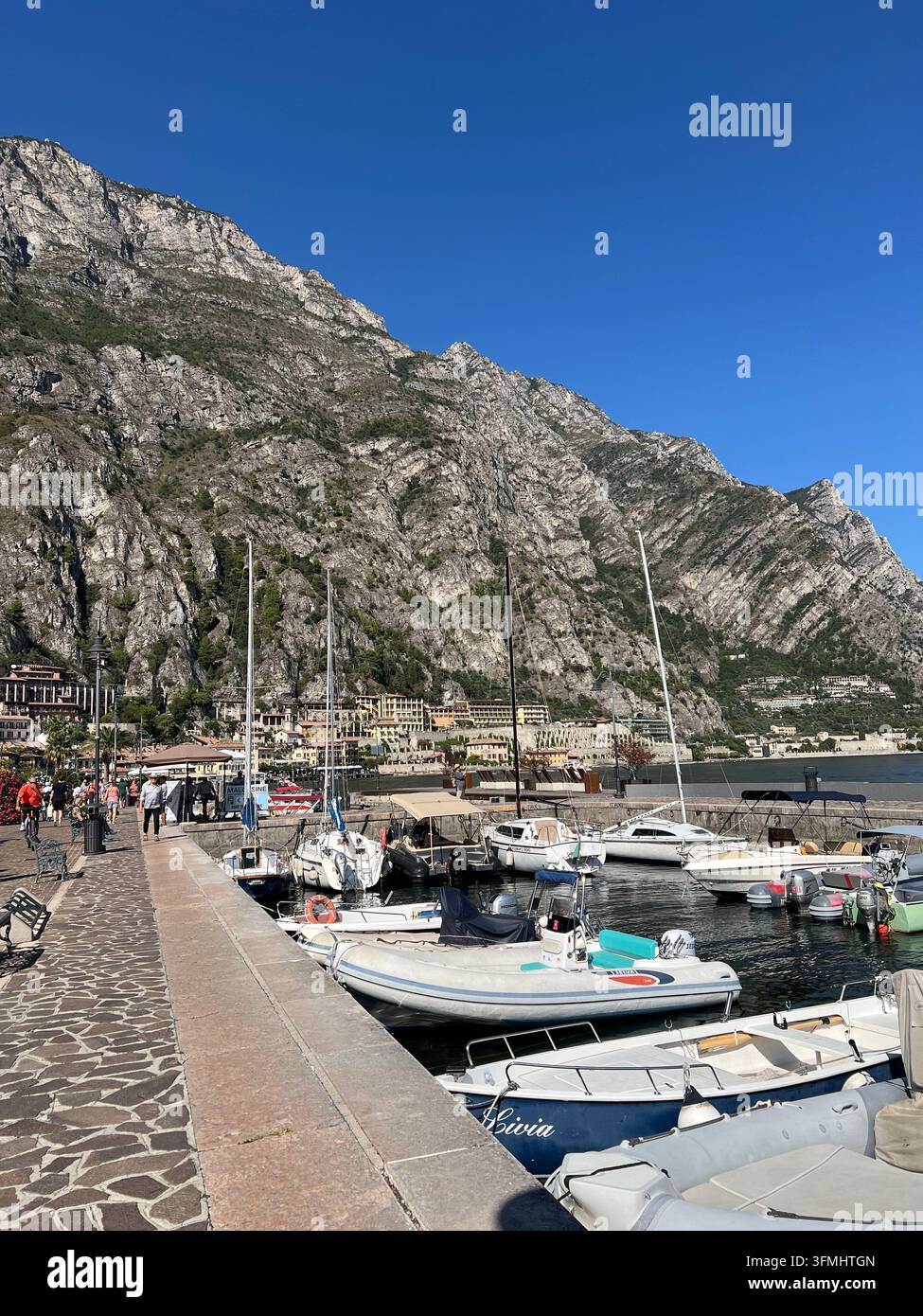 Motonavi e barche a vela ormeggiate a un molo sul lago di Garda a Limone sul Garda, Italia Foto Stock