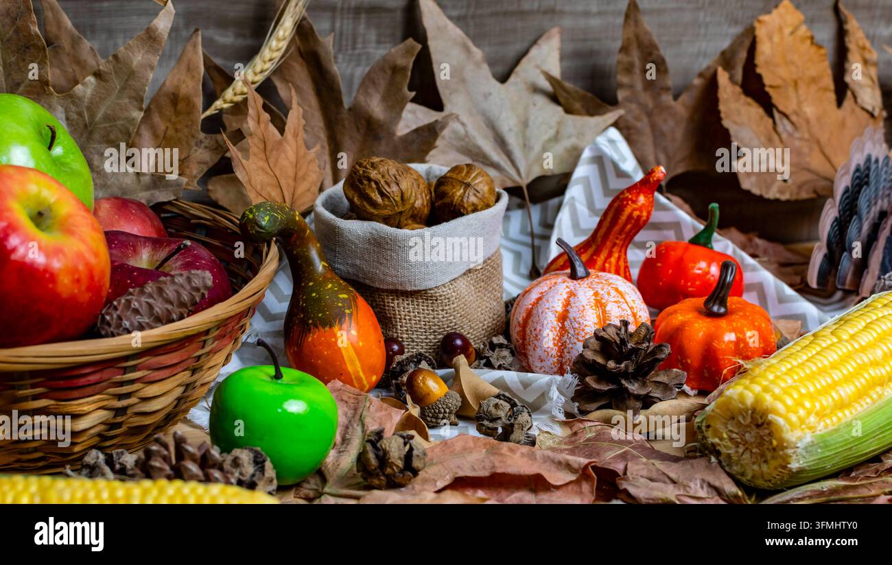Prodotti e decorazioni per il raccolto autunnale disposti con zucche, mele, noci e mais Foto Stock