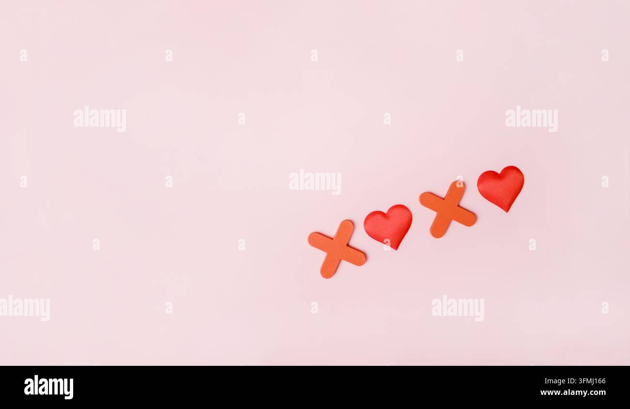 La frase "xoxo" su uno sfondo rosa. Concetto di baci e abbracci. Vista dall'alto, layout, spazio per il testo. Foto Stock
