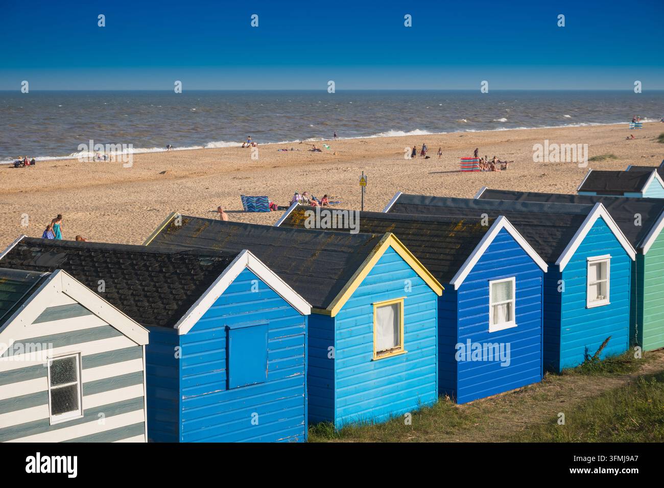 Suffolk, UK - 31 luglio 2026 - Una fila di capanne da spiaggia sotto un cielo blu alla spiaggia di Southwold Foto Stock