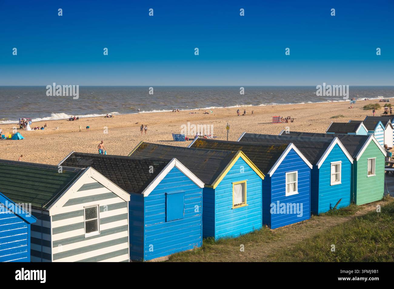 Suffolk, UK - 31 luglio 2026 - Una fila di capanne da spiaggia sotto un cielo blu alla spiaggia di Southwold Foto Stock