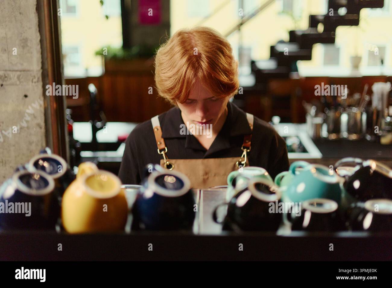 Barista maschile concentrato che prepara bevande al caffè in un caffè moderno Foto Stock