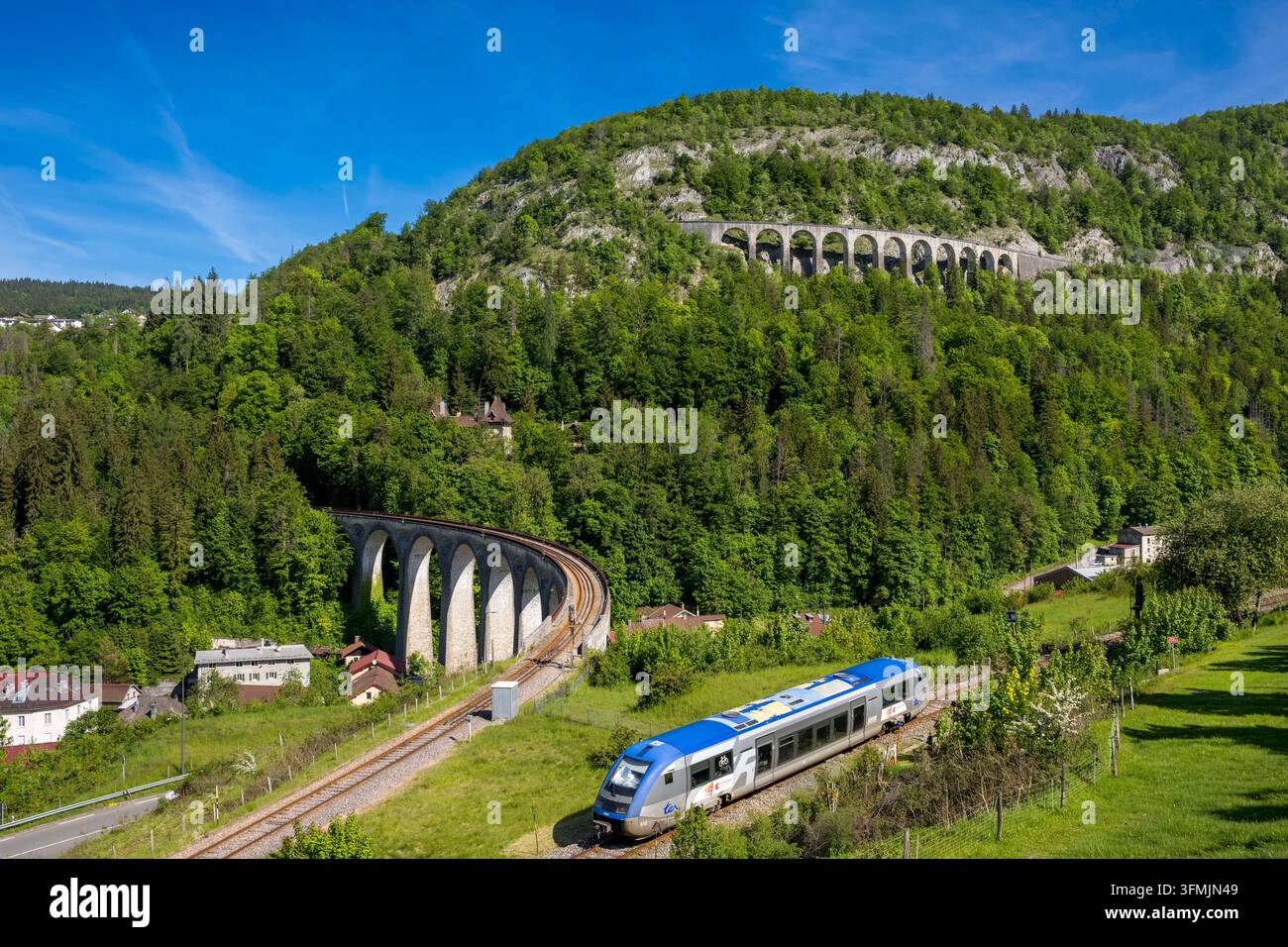 Francia, Giura, Morez, il viadotto di Morez sulla linea ferroviaria Morez-Saint-Claude delle Hirondelles e un treno TER sulla linea Morbier-Morez con il viadotto di Crottes sullo sfondo (vista aerea) Foto Stock