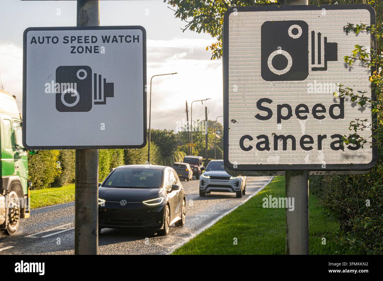 Zona di controllo automatico della velocità e cartelli di avvertimento delle telecamere a controllo velocità accanto a una strada con traffico in avvicinamento. Foto Stock