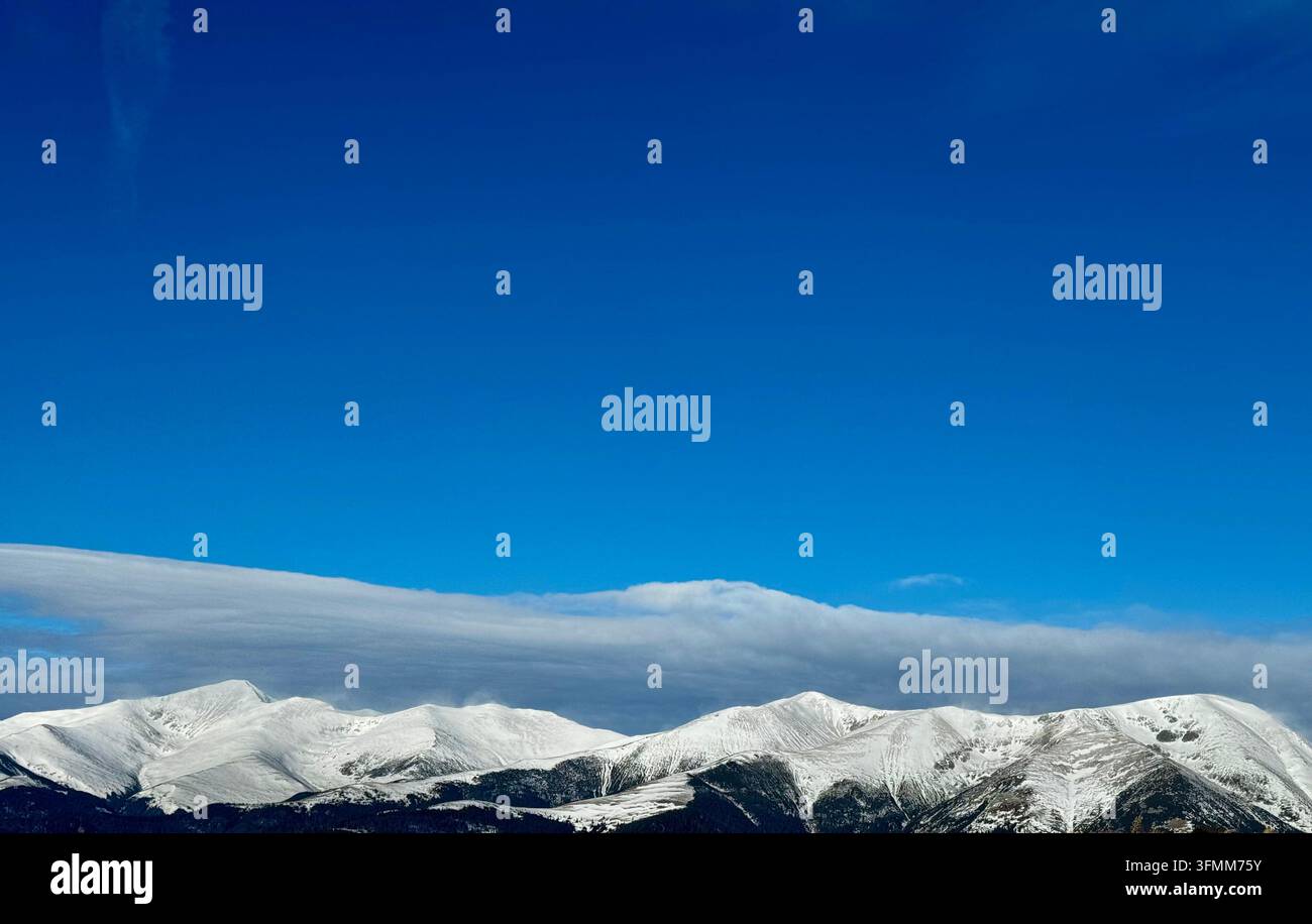 Maestosi picchi di montagna innevati sotto un cielo blu vibrante - Immagine stock catturata con smartphone