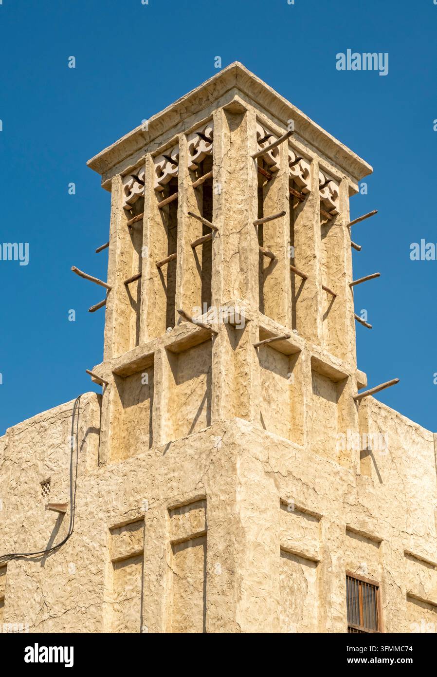 Vista dettagliata di una torre del vento tradizionale con travi in legno contro il cielo blu ad Al Seef, Vecchia Dubai, Dubai, Emirati Arabi Uniti Foto Stock