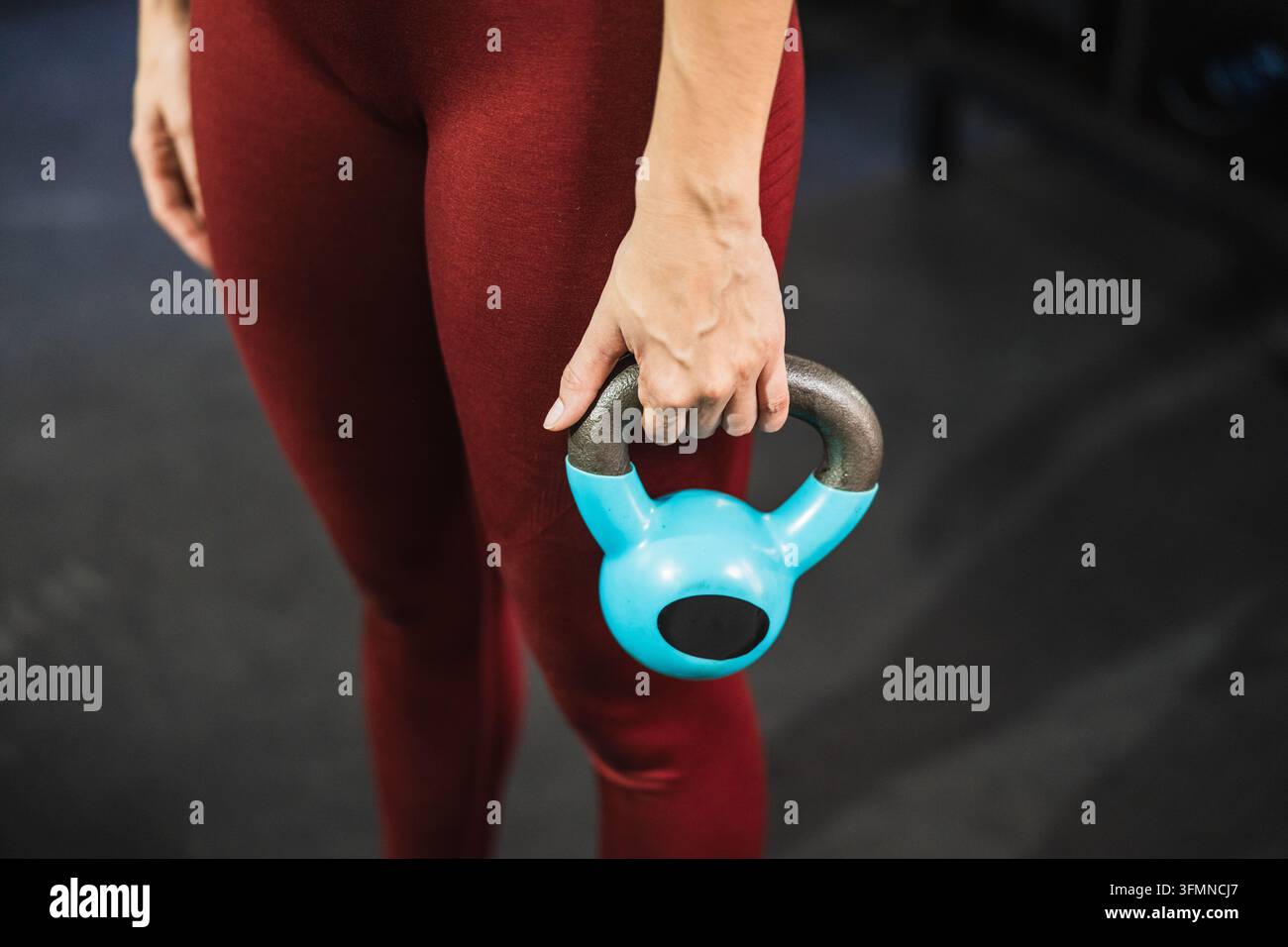 Mano di donna che tiene un kettlebell durante l'allenamento funzionale Foto Stock