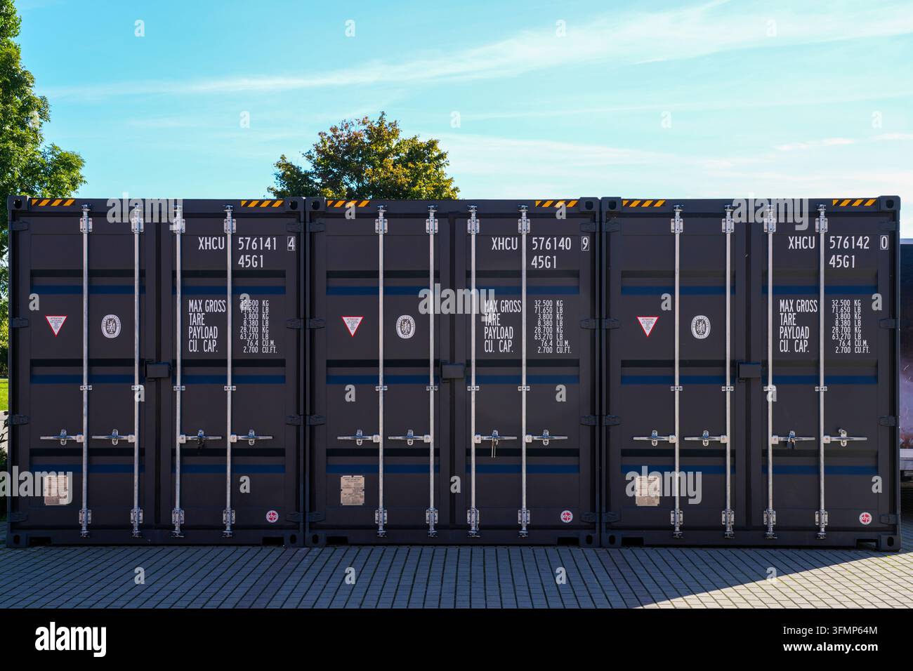 Liepaja, Lettonia - 27 settembre 2026: Tre container di spedizione in fila con porte di carico chiuse Foto Stock