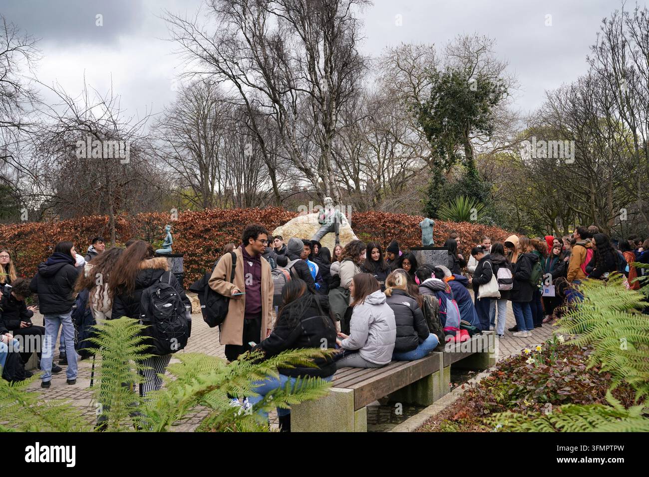 Grande gruppo turistico vicino alla statua di Oscar Wilde nel Merrion Square Park, Dublino Foto Stock