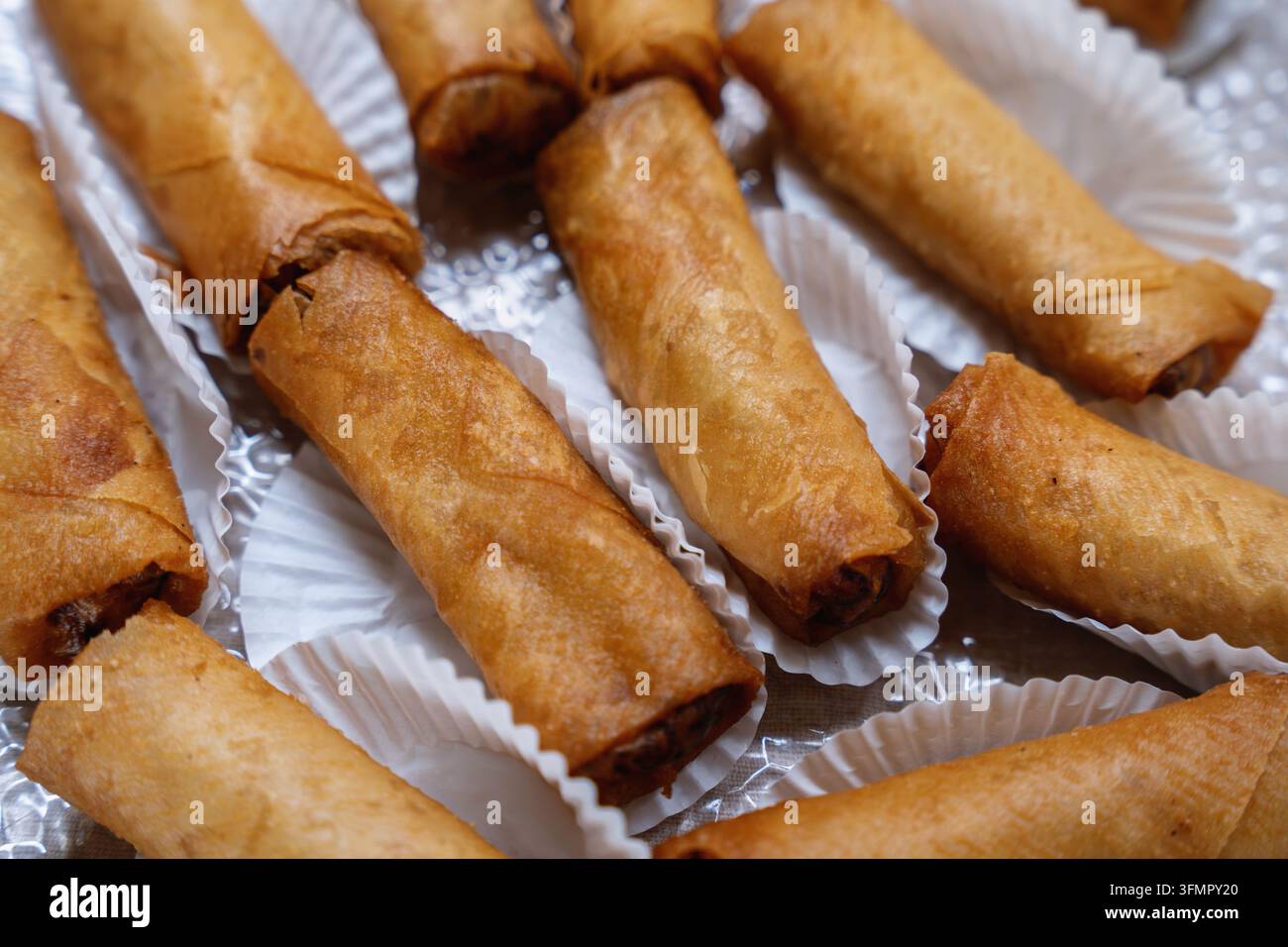 Rulli di primavera Lumpia dorati fritti croccanti serviti in singoli stampi di carta. Foto Stock