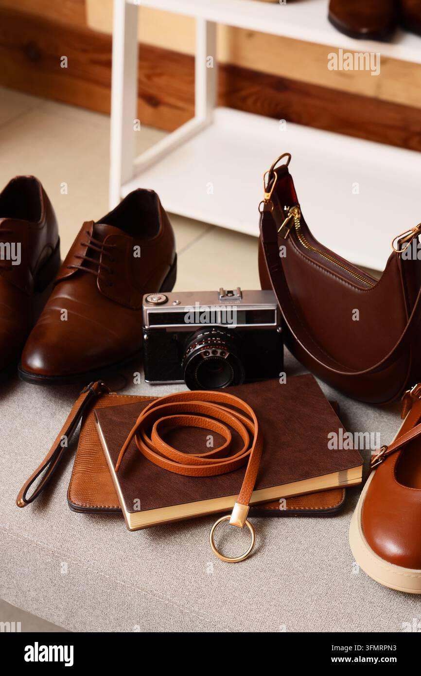 Accessori di moda e stile di vita, fotocamera vintage con scarpe di pelle e borsa per viaggi e fotografia di stile personale su una superficie neutra Foto Stock