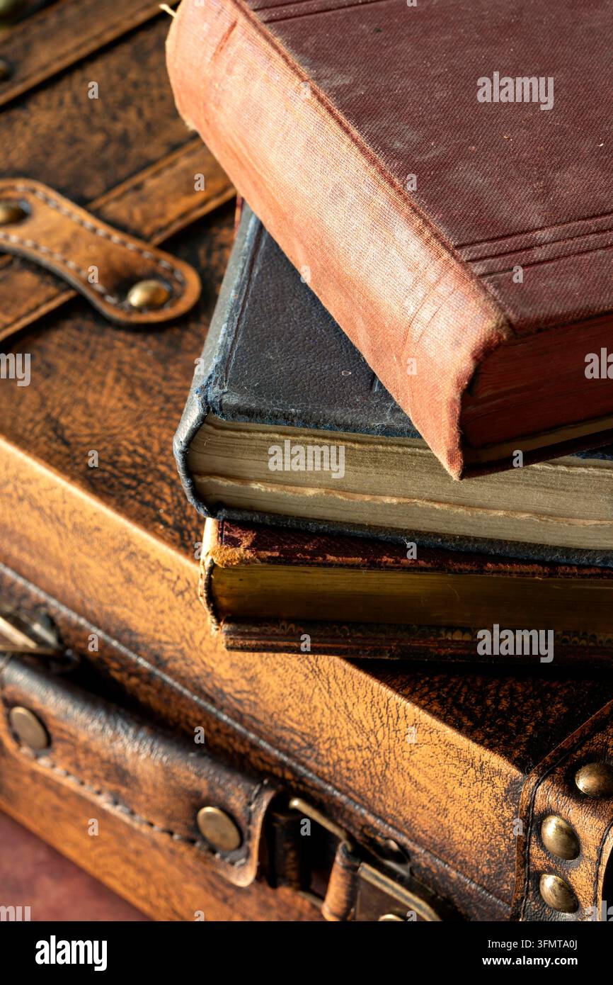 Vecchi libri vintage e antichi sopra una valigia in pelle vintage. Concetto di sfondo per viaggi vintage. Foto Stock