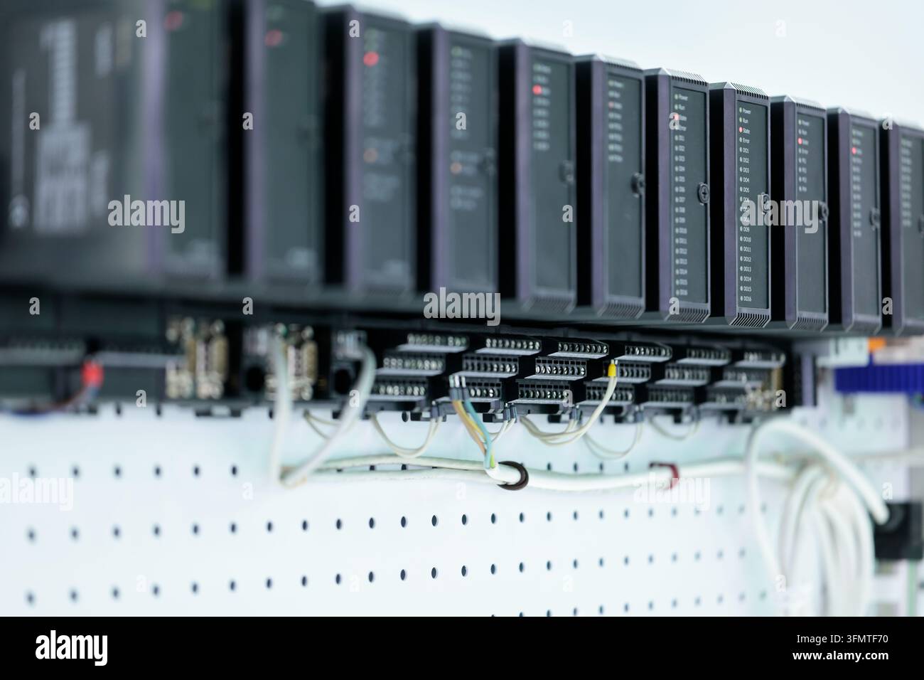 Primo piano di un sistema di automazione industriale basato su PLC montato su pannello forato. Messa a fuoco selettiva. Foto Stock