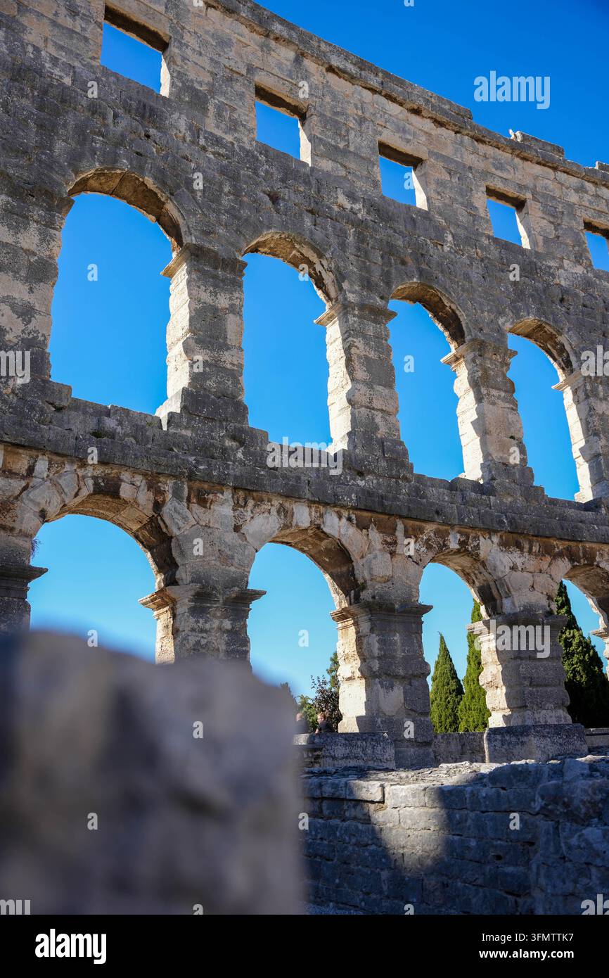 Reportage di viaggio / Nell'immagine: Impressioni dell'Arena di Pola (Anfiteatro di Pola) nella Contea dell'Istria (Croazia). Questo edificio romano ben conservato è il simbolo della città e rientra tra i più grandi anfiteatri ancora in piedi dell'Impero romano. Oggi, l'edificio antico funge da impressionante sfondo per concerti, opere, festival cinematografici ed è una delle attrazioni più importanti per i turisti in Istria. L'immagine simboleggia Arena di Pola, Anfiteatro, Pola, Istria, Croazia, Impero romano, Antichità, Architettura, Storia, Sito turistico, Punto di riferimento, Cultura, Som Foto Stock