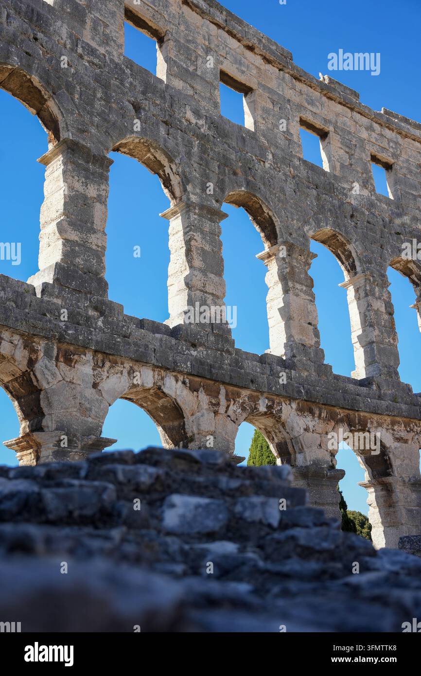 Reportage di viaggio / Nell'immagine: Impressioni dell'Arena di Pola (Anfiteatro di Pola) nella Contea dell'Istria (Croazia). Questo edificio romano ben conservato è il simbolo della città e rientra tra i più grandi anfiteatri ancora in piedi dell'Impero romano. Oggi, l'edificio antico funge da impressionante sfondo per concerti, opere, festival cinematografici ed è una delle attrazioni più importanti per i turisti in Istria. L'immagine simboleggia Arena di Pola, Anfiteatro, Pola, Istria, Croazia, Impero romano, Antichità, Architettura, Storia, Sito turistico, Punto di riferimento, Cultura, Som Foto Stock