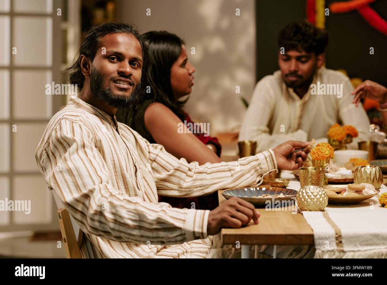 Ritratto di un uomo indiano che celebra una cena festosa con gli amici Foto Stock