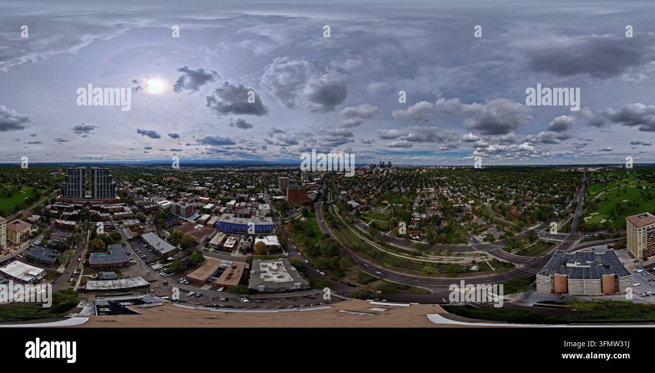 Veduta aerea di Cherry Creek che si snoda attraverso il paesaggio urbano di Denver con edifici residenziali, alberi rigogliosi e strade sotto un cielo nuvoloso i Foto Stock