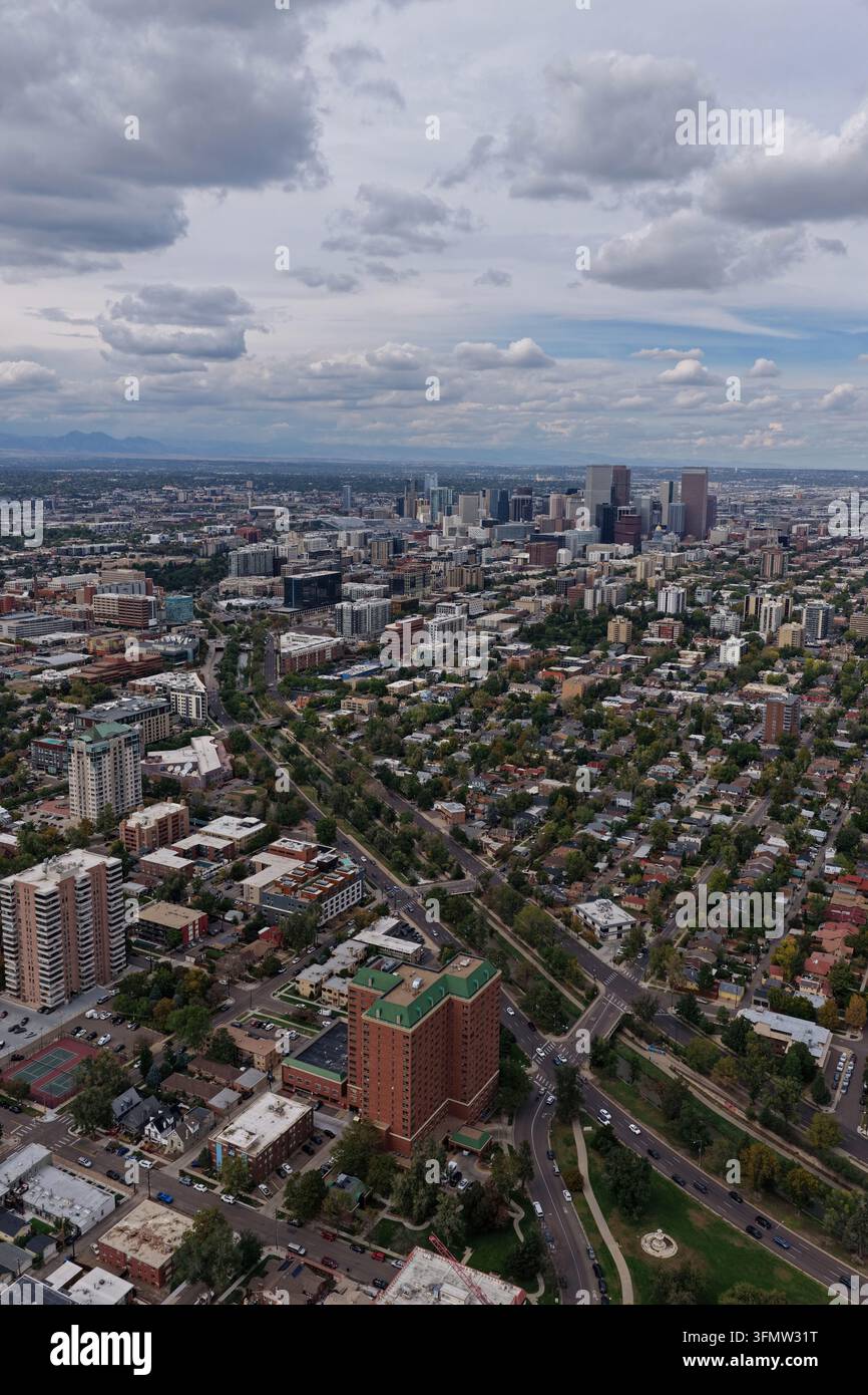 Vista aerea dello skyline di Denver e dell'area di Cherry Creek con grattacieli, quartieri residenziali e strade urbane sotto un cielo nuvoloso i Foto Stock