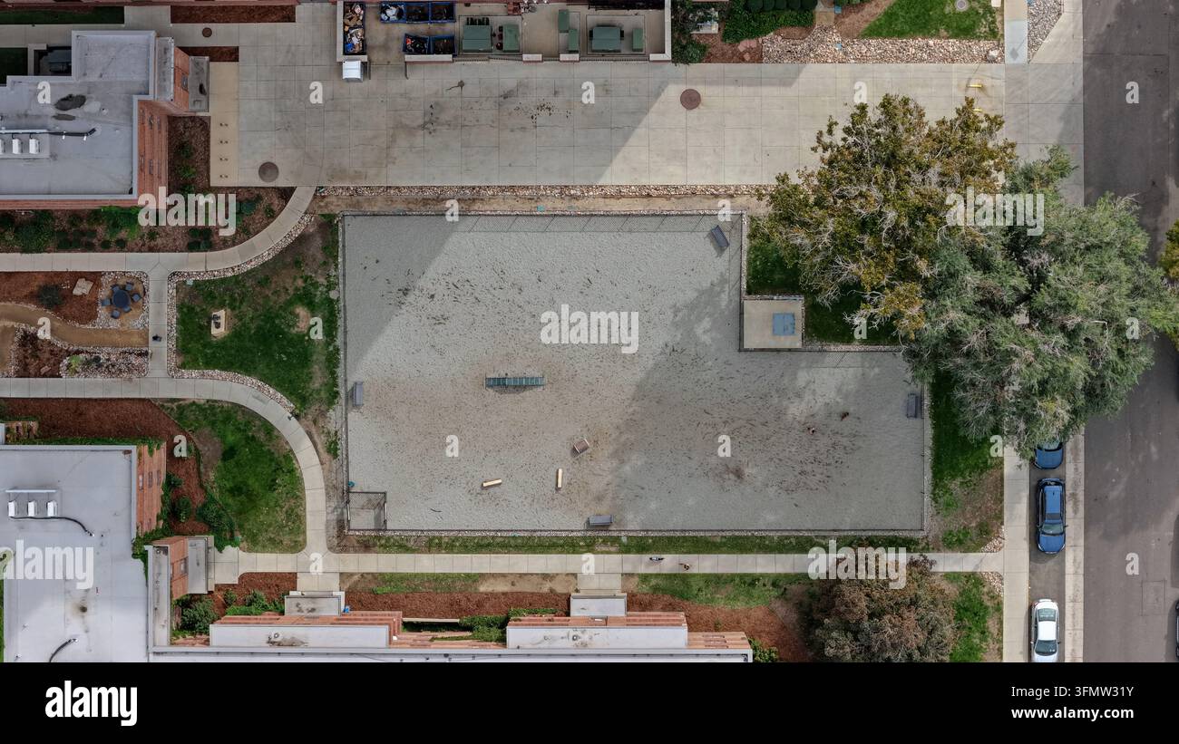 Vista aerea di un parco per cani recintato nell'area di Cherry Creek con terreno sabbioso, attrezzature da agilità, passeggiate circostanti e alberi maturi a Denver, Colo Foto Stock