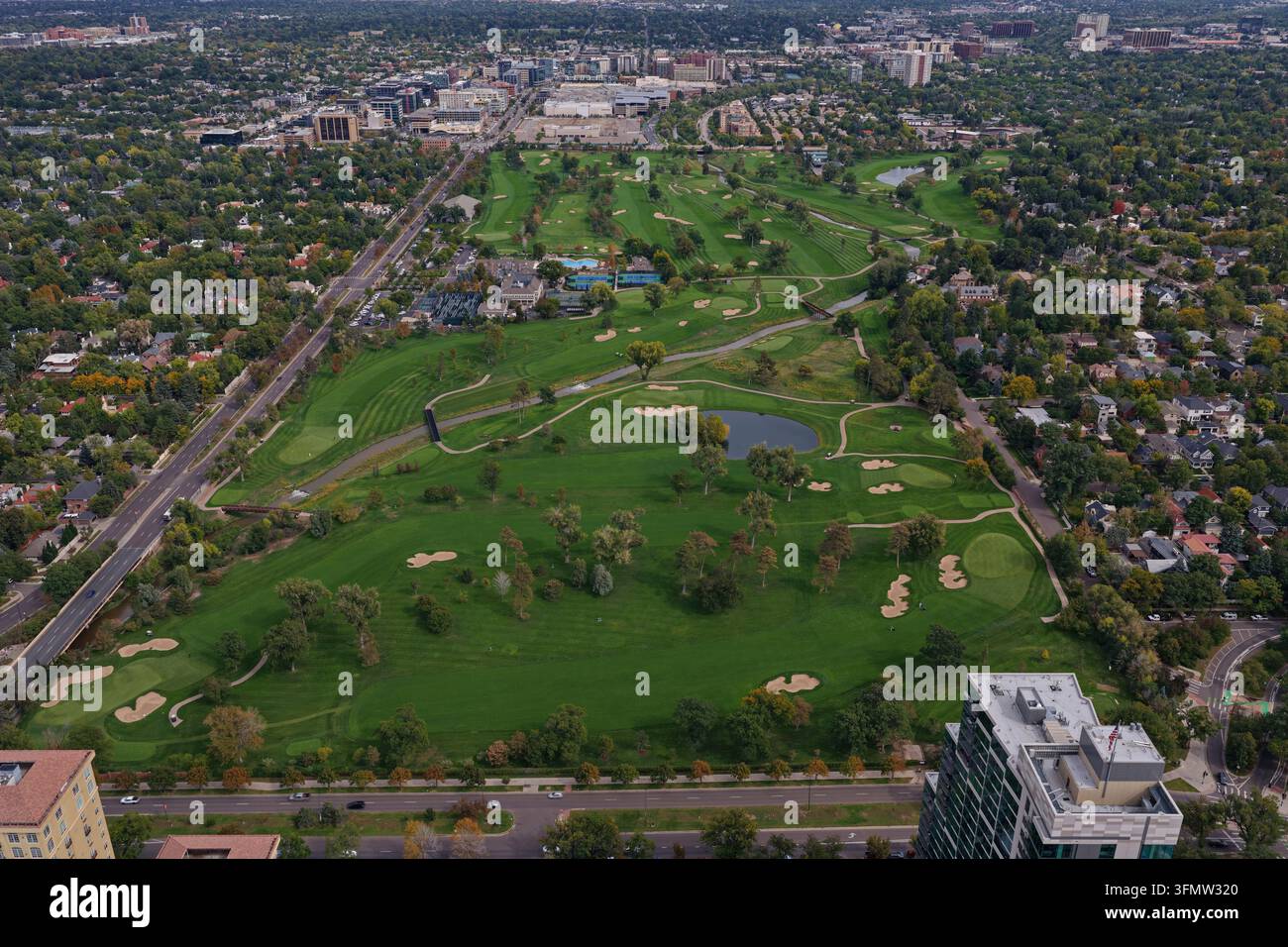 Vista aerea del campo da golf Cherry Creek con rigogliosi fairway verdi, bunker di sabbia e un piccolo stagno circondato da un quartiere residenziale urbano Foto Stock