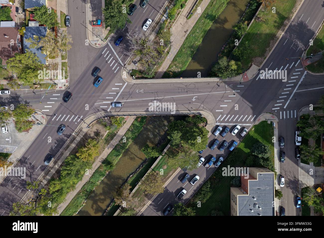 Vista aerea del Cherry Creek che scorre sotto un incrocio stradale con traffico e la vegetazione urbana circostante a Denver, Colorado, Stati Uniti. Foto Stock