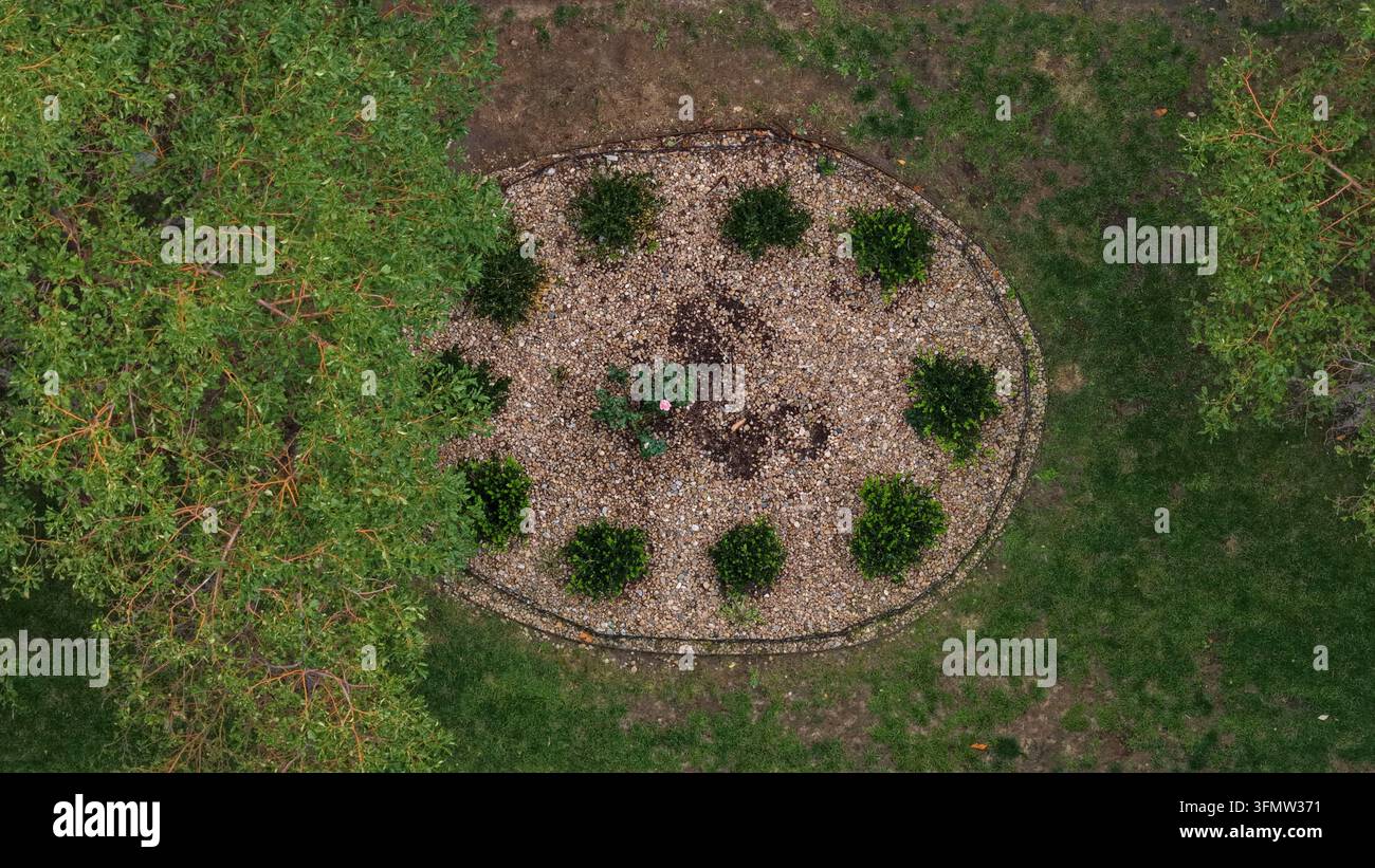 Vista aerea di un'aiuola circolare con ghiaia, piccoli arbusti e una pianta centrale, circondata da erba e alberi a Cherry Creek, Denver, Colorado Foto Stock