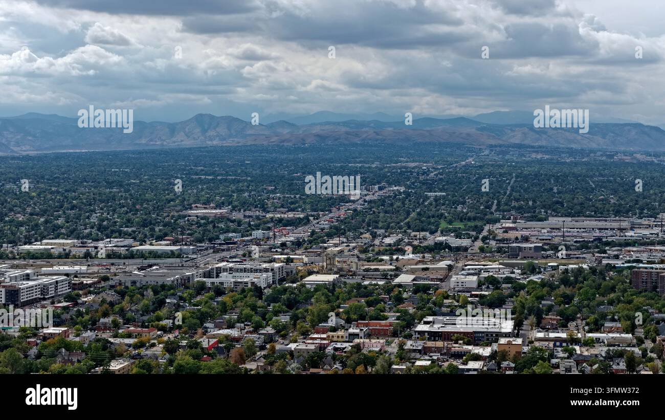 Vista aerea dell'area di Cherry Creek con sviluppo urbano, quartieri residenziali e alberi rigogliosi con le Montagne Rocciose sullo sfondo Foto Stock