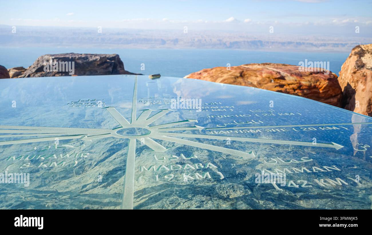 Vista del segnatore di orientamento della bussola in vetro al punto panoramico del Monte Nebo che si affaccia sul paesaggio accidentato e sul Mar Morto a Madaba, Governatorato di Madaba Foto Stock