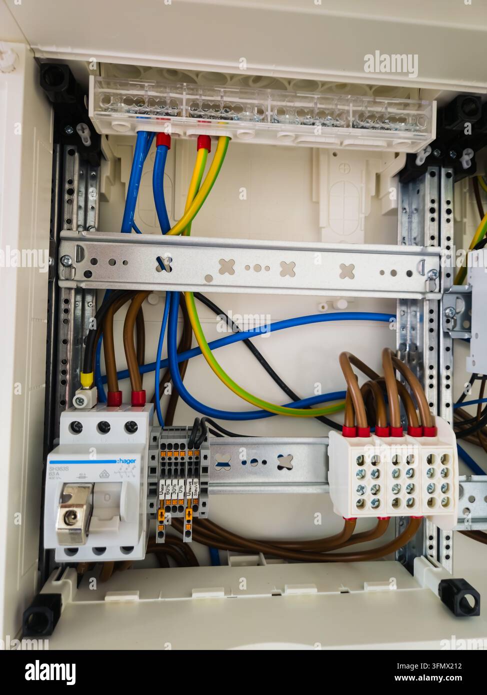 Pannello di distribuzione elettrica con interruttore a tempo, morsetti di collegamento e cablaggio colorato all'interno di un'installazione elettrica residenziale. Foto Stock