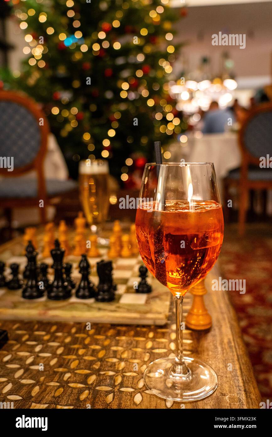 Bevanda festiva e partita di scacchi con luci dell'albero di Natale Foto Stock