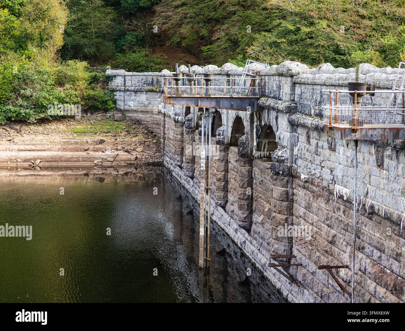 Muro del bacino in granito e misuratore di profondità del serbatoio di Burrator, Dartmoor, Wrst Devon, UK che mostra bassi livelli d'acqua dopo la siccità del 2026 Foto Stock