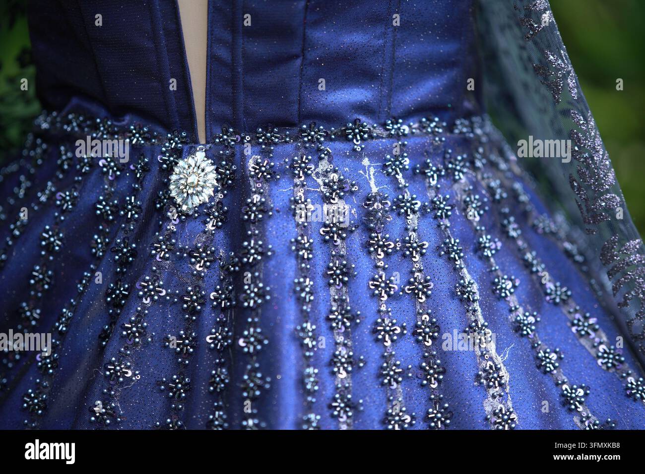 Prima piano di un lussuoso abito da sera blu ricamato con perline e paillettes Foto Stock