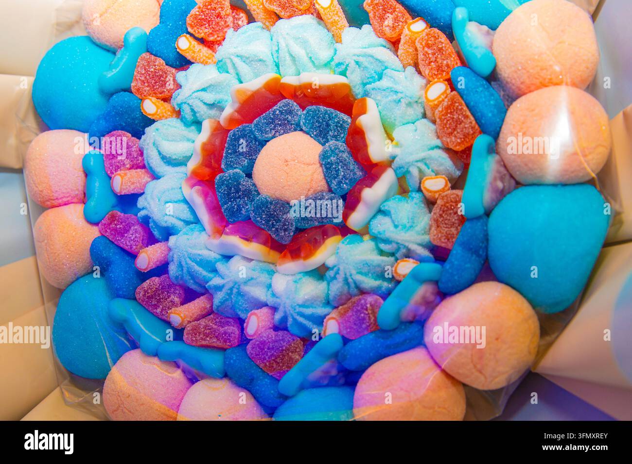Caramelle gommose colorate e marshmallow disposti in cerchi concentrici all'interno di una scatola Foto Stock